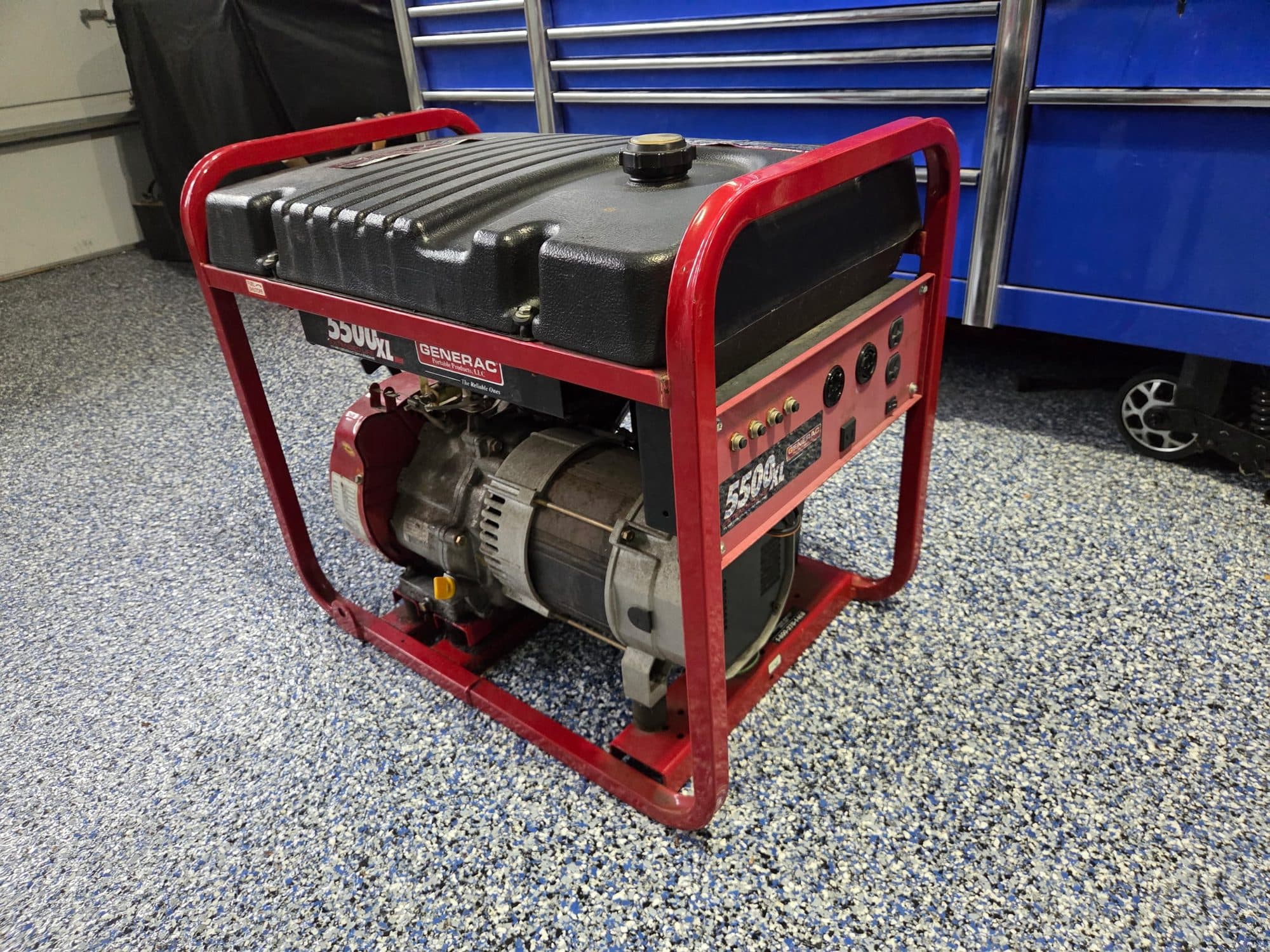 A portable generator on the epoxy floor of the shop, tool chests behind it